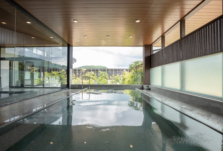 温泉高濃度炭酸泉のほのかな泡と湯気の立つ浴槽