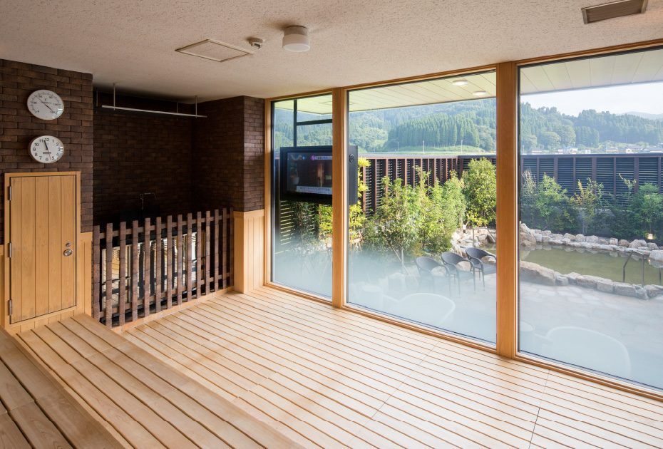 ガラス張りサウナ室内と外の山並みを望む風景