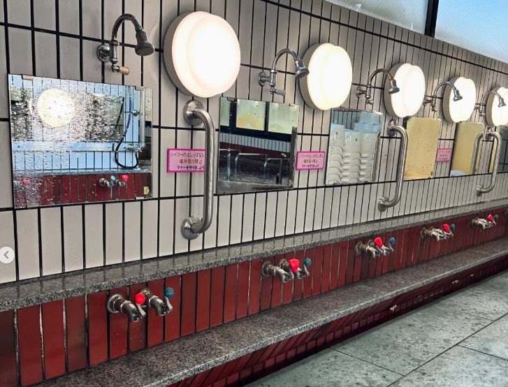 “浴場内洗い場 シャワーヘッドと清潔なカラン”